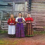 Młode chłopskie dziewczęta w drewnianym domu, we wsi pod Kiriłłowem w obwodzie wołogodzkim. Kobiety częstują gościa jagodami przed wejściem do izby, fot. Siergiej Prokudin-Gorski, 1909 r.