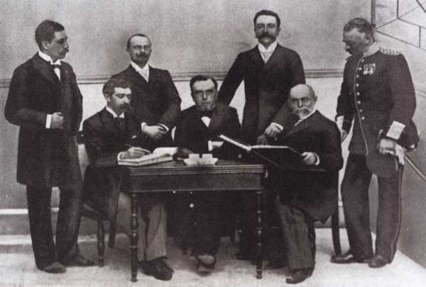 Niektórzy ówcześni członkowie Międzynarodowego Komitetu Olimpijskiego, siedzą od lewej: Pierre de Coubertin (Francja), Dimitrios Wikielas (Grecja)